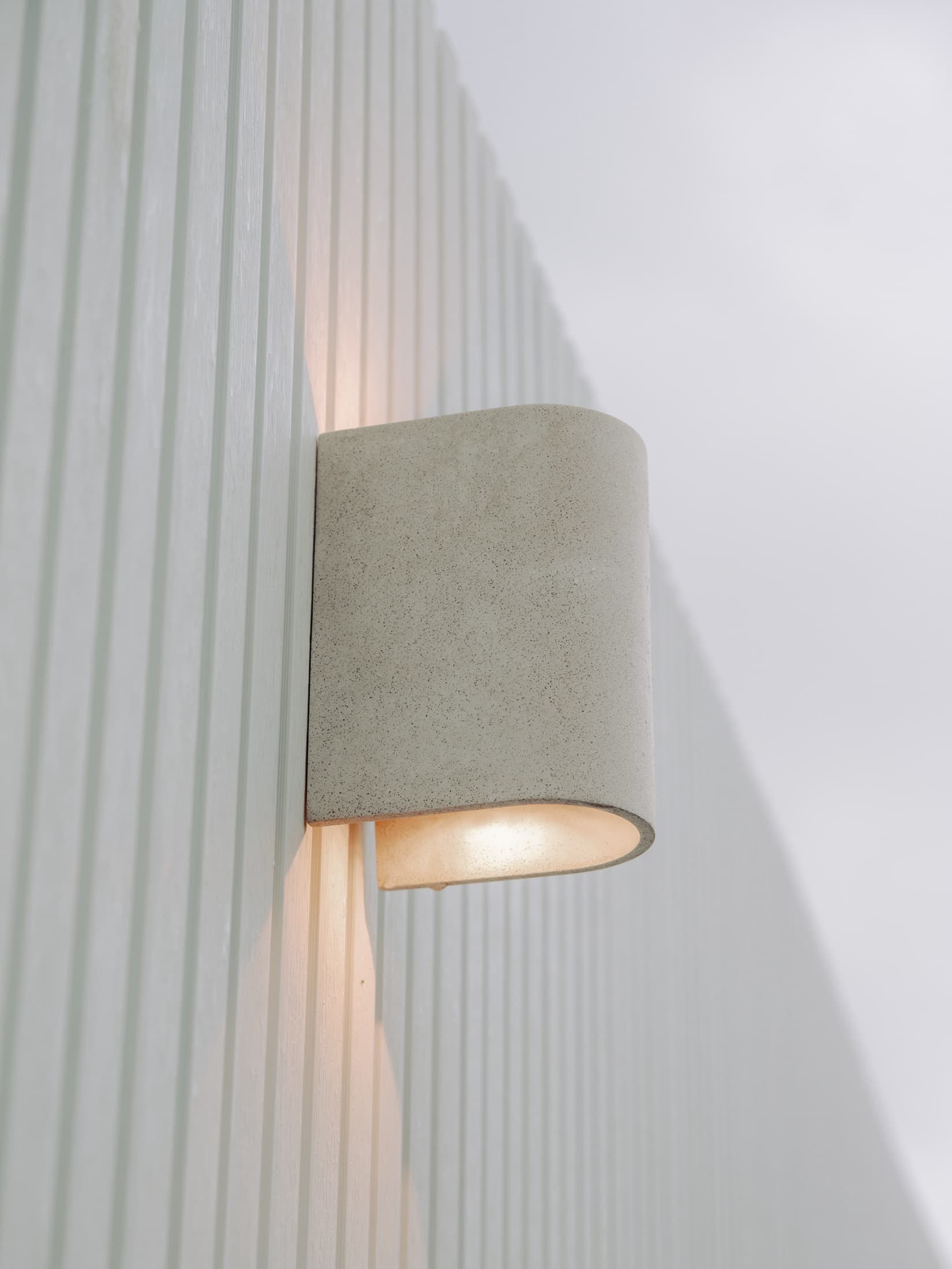 Exterior wall light against vertical cladding in a completed Clyde North project