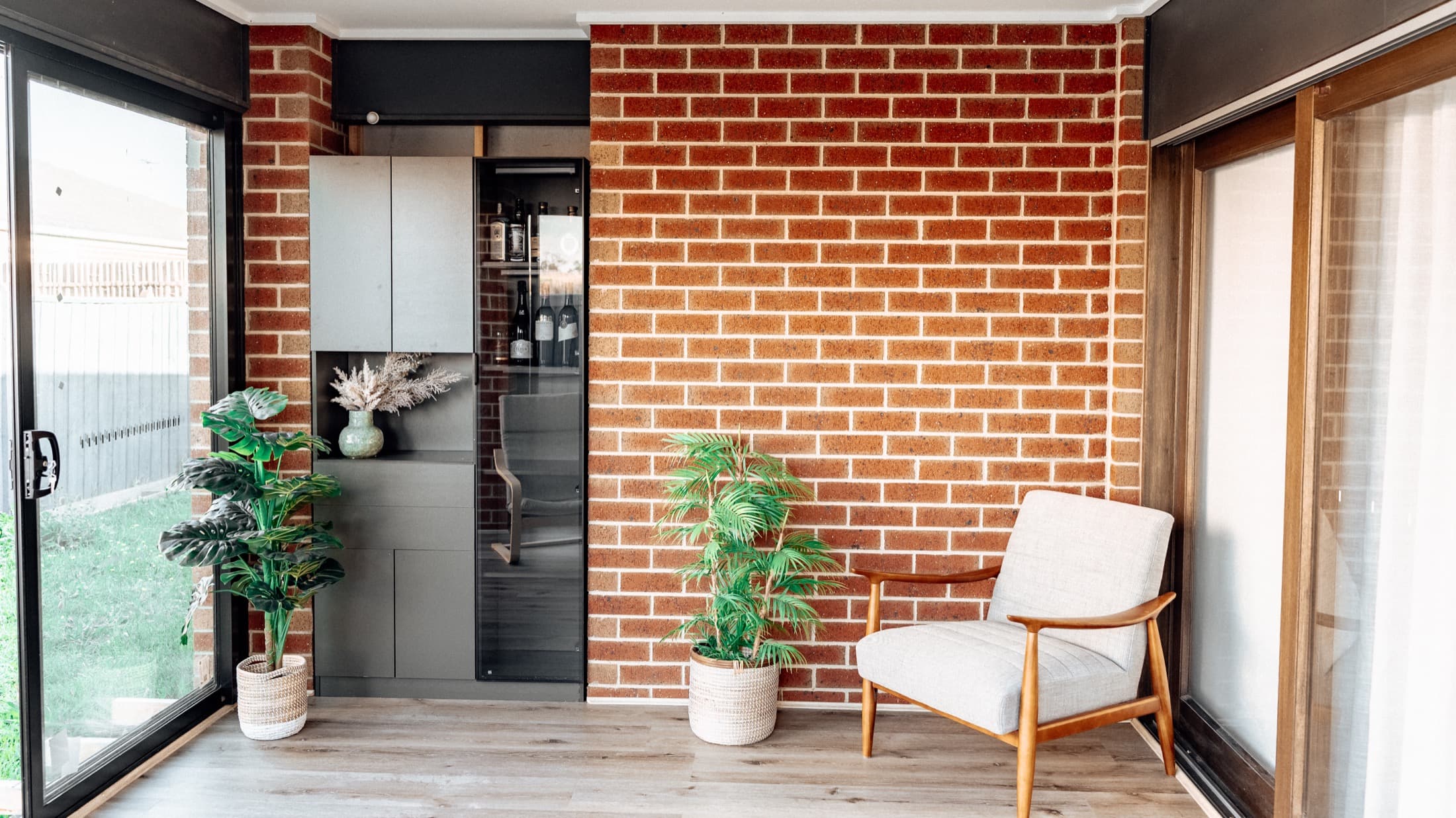Finished lifestyle room in Cranbourne with brick walls, glazing and a seated corner